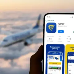 Telefon z aplikacją Ryanair, gotowy do rezerwacji lotu. W tle samolot przelatujący nad chmurami.