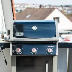 Weber Gasgrill auf dem Balkon: Grillen erlaubt! Mit Fleisch und Gewürzen bereit für den Genuss.