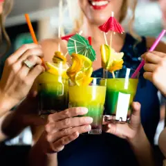 Amici brindano con cocktail colorati, un assaggio di divertimento nelle discoteche di Barceloneta.