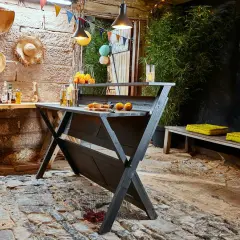 Rustikale Bar selber bauen: Eine dunkle Holzbar mit Orangen und Getränken, dekoriert mit bunten Wimpeln und Hüten. Perfekt für Gartenpartys.