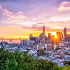 Zachód słońca nad San Francisco, idealne miejsce na wakacje w Stanach Zjednoczonych. Most Golden Gate i drapacze chmur w złotej poświacie.