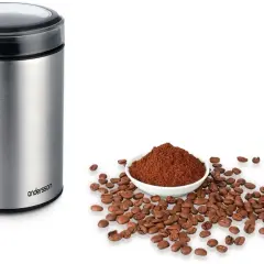 En kaffekvarn i metall bredvid en skål med kaffepulver och bönor. Perfekt för att lära sig hur brygger man kaffe.