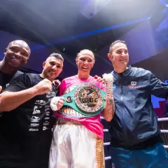Patricia Berghult firar sin seger med sitt team, bärandes ett WBC-mästarbälte.