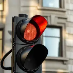 Un feu rouge clignote, signalant un danger. Le radar est prêt à flasher une fois.