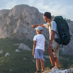 Ojciec z synem patrzą na góry. Zastanawiają się, ile kosztuje noc w schronisku w Tatrach.