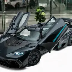 Szary Mercedes-AMG ONE z otwartymi drzwiami, prezentujący swoje futurystyczne linie i sportowy charakter.