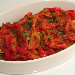 Pescado de roca gallego horneado con pimientos rojos y perejil.