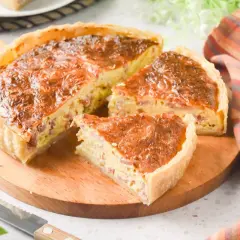 Un delicioso quiche de bacon, recién horneado y cortado en porciones, listo para disfrutar.