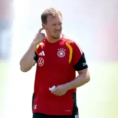 Trener reprezentacji Niemiec, Julian Nagelsmann, w czerwonej koszulce z godłem DFB, gestykuluje podczas treningu.