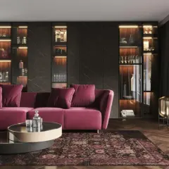 Elegancki salon z sofą w kolorze fuksji i dywanem w stylu art deco malarstwo. Podświetlane witryny pełne szkła i dekoracji.