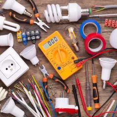 Wszystkie potrzebne materiały do instalacji elektrycznych: kable, żarówki, gniazdko, miernik, taśmy i narzędzia. Idealne dla hurtowni kabli i osprzętu elektroinstalacyjnego.