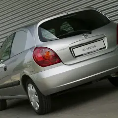 Srebrny Nissan Almera N16 z tyłu, z widocznym napisem "ALMERA NISSAN ÖSTERREICH" na klapie bagażnika.