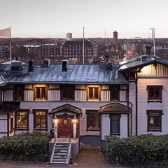 Vacker villa med utsikt över Trollhättan. Albert, en historisk byggnad, badar i kvällsljus.