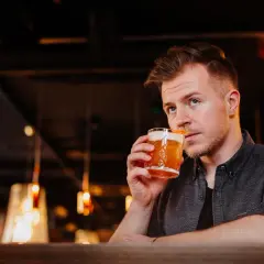 Mężczyzna popija drinka, który wygląda jak klasyczny whisky sour. Idealny przepis na wieczór.
