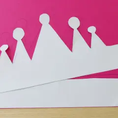 Sagoma di una corona da colorare su carta fucsia, pronta per essere ritagliata e decorata.