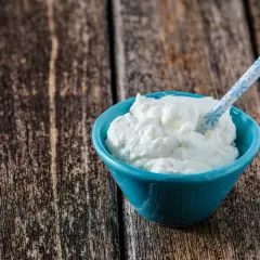 Ein blauer Napf mit cremigem Skyr oder Magerquark, bereit zum Genuss.