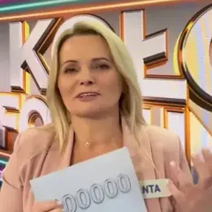 Kobieta z Koła Fortuny trzyma kartę z napisem "00000", zastanawiając się, co daje złota karta w kole fortuny.