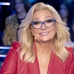 Małgorzata Walewska w czerwonej marynarce i okularach, uśmiecha się.