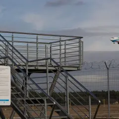 Osoba na tarasie widokowym Pyrzowice robi zdjęcie samolotu Enter Air lądującego na lotnisku.