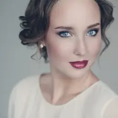 Maquillaje para vestido blanco: ojos ahumados, labios rojos y peinado recogido.