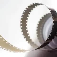 Zwijająca się taśma filmowa z perforacją. Zastanawiasz się, ile kosztują klisze do aparatu?