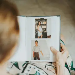 Otwarty album ze zdjęciami: młoda kobieta w ciąży i uśmiechnięty mężczyzna. Wspaniały pomysł na własny album pełen wspomnień.