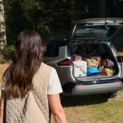 Para wyładowuje bagażnik Toyoty RAV4, gotowa na przygodę. Wymiary bagażnika pozwalają na spakowanie wszystkiego.