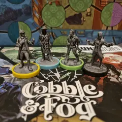 Cztery figurki postaci z gry planszowej "Cobble & Fog" na tle planszy. Atmosfera unmatched bruk i mgła.