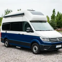 Nowoczesna produkcja kamperów: biało-niebieski Volkswagen Crafter z zabudową kempingową, gotowy na przygody.