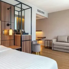 Ett modernt hotellrum på AC Hotel Solna med en bekväm säng, soffa och stilren inredning.
