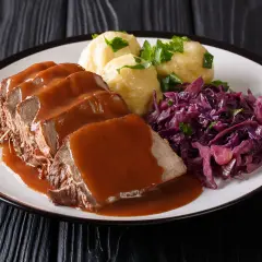 Ein Teller mit saftigem Sauerbraten, Klößen und Rotkohl. Perfekt für die Schwangerschaft, wenn man Lust auf Hausmannskost hat.