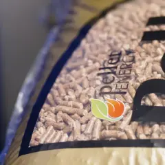 Zbliżenie na worek z pelletem drzewnym. Logo "Pellet Energy" i płomień z liściem. Dowiedz się, jak zrobic pellet.