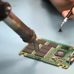Reparatur einer SSD. Ein Lötkolben erwärmt die Platine, um mögliche ssd defekt symptome zu beheben.