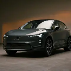 Nowoczesny, ciemnoszary Volvo EX60 z charakterystycznymi światłami LED stoi na betonowej podłodze.