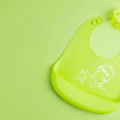 Ljusgrön haklapp med gulliga kycklingar, en riktig haklapp bäst i test för små matälskare.
