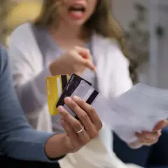 Kłótnia o finanse. Czy mąż powinien dawać żonie pieniądze? Para z kartami kredytowymi i rachunkami w rękach.