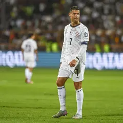 Cristiano Ronaldo w białej koszulce z numerem 7 na boisku piłkarskim.