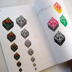 A book page displays variations of the iconic "NeXT" logo, showcasing Paul Rand's famous works and exploring different color combinations.