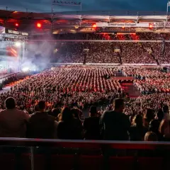 Ein riesiges Publikum feiert bei einem Teddy Show Konzert in der MHP Arena Stuttgart. Die Bühne erstrahlt in bunten Lichtern.