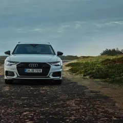 Audi A6 Avant blanche sur une route côtière. La plaque d'immatriculation "IN BE 719E" permet de connaître le modèle de voiture.