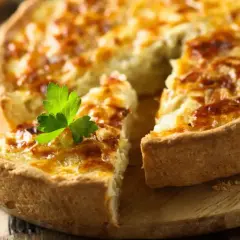 Une quiche dorée, garnie de persil, prête pour la conservation au frigo. Parfaite pour un repas rapide.