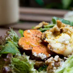 Deliciosa ensalada de batata asada con queso de cabra cremoso, nueces crujientes y hojas verdes frescas.