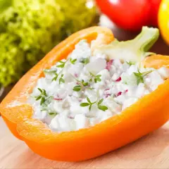 Pomarańczowa papryka faszerowana twarożkiem i ziołami. Papryka właściwości odżywcze czynią ją idealną bazą dla zdrowych przekąsek.
