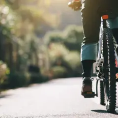 Persona pedaleando en un camino soleado, sintiendo la libertad de soñar con bicicleta.