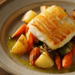 Filete de bacalao dorado con patatas y zanahorias asadas, una deliciosa forma de como hacer bacalao.