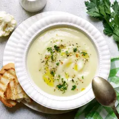 Crema de coliflor, una de las mejores coliflor recetas, servida con pan tostado y perejil fresco.