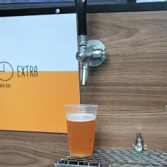 Dwa piwa w plastikowych kubkach pod kranikami. Jedno jasne, drugie ciemne. Logo "Hora Extra Beer Bike" z boku. Idealne na piwo bez chmielu.