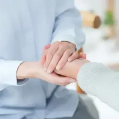 Dwie osoby trzymają się za ręce, symbolizując wsparcie i troskę. To obraz, który może kojarzyć się z nadchodzącym świadczeniem wspierającym 2025.