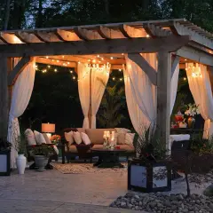 Mysig altan inspiration med draperade gardiner, ljusslingor och bekväma möbler. Perfekt för sommarkvällar.