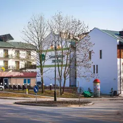 Sanatorium & pensjonat Zbyszko, z restauracją, zaprasza gości. Budynki z balkonami i zielonym dachem.